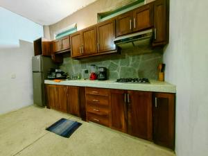 a kitchen with wooden cabinets and a stove top oven at VILLA DEL PEZ in Sayulita