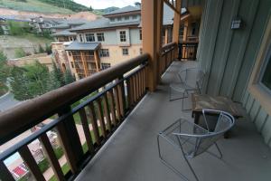 a balcony with two chairs and a table on it at Rustic Lofted Steps from Mountain Adventure in Park City