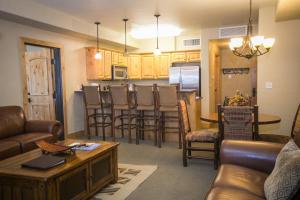a living room with a couch and a table and a kitchen at Silverado 312D in Park City