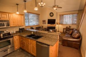 a kitchen with a sink and a stove top oven at Canyons Village Location Oversized Deck Off in Park City