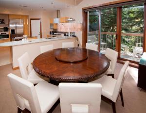 a dining room with a wooden table and white chairs at Osprey 303 in Beaver Creek