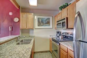 a kitchen with wooden cabinets and a stainless steel refrigerator at River Mnt Lodge E302 in Breckenridge