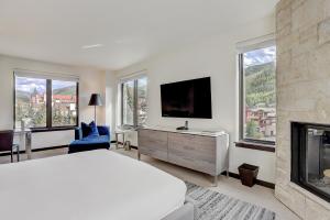 a bedroom with a bed and a tv and a fireplace at The Lion Vail- 4 Br Modern Mountain Luxury- 2966 Sq Ft Condo in Vail