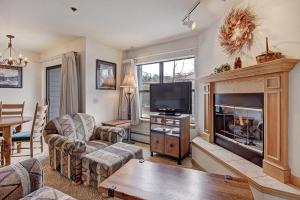 a living room with a fireplace and a tv at River Mtn Lodge W219 in Breckenridge