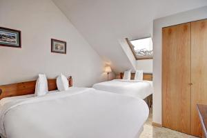 two white beds in a room with a window at River Mtn Lodge W219 in Breckenridge