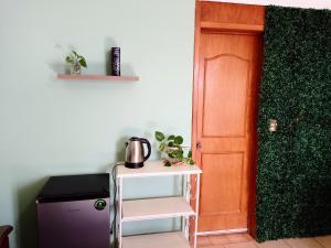 mały stolik z czajnikiem obok drzwi w obiekcie Habitación independiente colibrí w mieście Aguascalientes