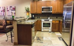 une cuisine avec des placards en bois et des appareils en acier inoxydable dans l'établissement Catamount 407C, à Truckee