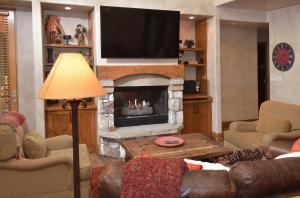 a living room with a fireplace with a flat screen tv at Elkhorn 509 in Avon
