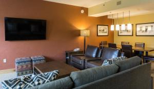a living room with a couch and chairs and a flat screen tv at Luxury suite in the heart of Canyons Village in Park City