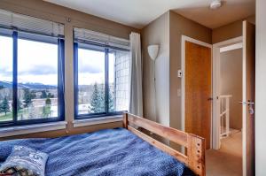 Un dormitorio con una cama y grandes ventanales. en Plaza 1407, en Keystone