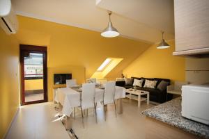 sala de estar con mesa y sillas blancas en dp Ático Deluxe, en Sarria