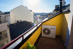 a balcony of a yellow building with a fan at dp Ático Deluxe in Sarria