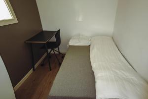 a small bedroom with a bed next to a desk at Beautiful apartment in Tromsø in Tromsø