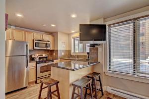 a kitchen with a stainless steel refrigerator and stools at Village at Breck V4309 in Breckenridge