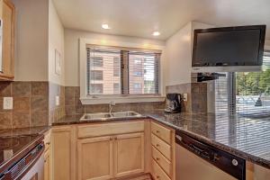 a kitchen with a sink and a flat screen tv at Village at Breck V4309 in Breckenridge