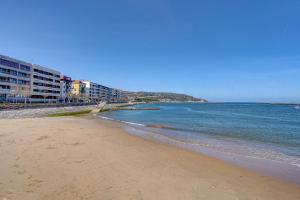 uma praia de areia com edifícios e o oceano em Maravilloso apartamento en el corazón de Hondarribia em Hondarribia