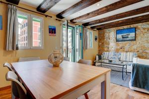 uma sala de jantar com uma mesa de madeira e cadeiras em Maravilloso apartamento en el corazón de Hondarribia em Hondarribia