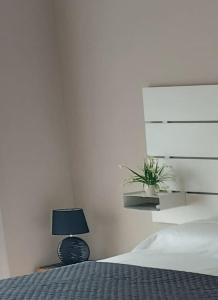 biała sypialnia z łóżkiem i lampką w obiekcie Milano SanSiroHouse Rho MI Fiera w Mediolanie
