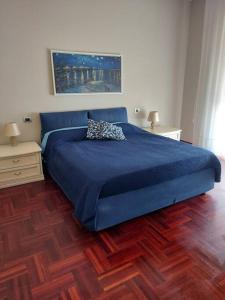 een slaapkamer met een blauw bed en 2 nachtkastjes bij Milano SanSiroHouse Rho MI Fiera in Milaan