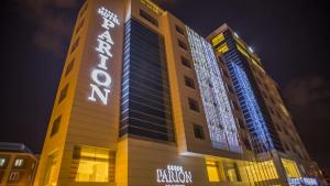 a tall building with a sign on it at night at Parion Hotel in Çanakkale