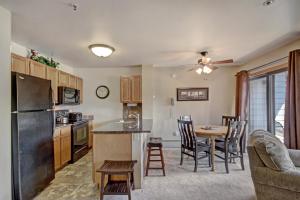 a kitchen and living room with a table and a refrigerator at River Mtn Lodge E205 in Breckenridge