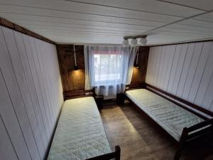 um quarto com duas camas e uma janela em Ilūkstes Sauna apartamenti (bezkontakta) em Ilūkste