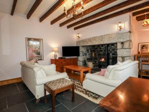 a living room with two couches and a fireplace at Roskorwell Manor in Helston