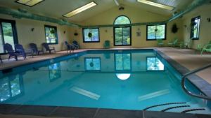 a swimming pool with blue water in a room with windows at Winterplace 3 Br- Plenty Of Bedding- Great For Families Condo in Ludlow