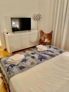 a bedroom with a bed with a dresser and a television at Corso Italia 4 in Bordighera