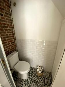 Elle comprend une petite salle de bains pourvue de toilettes et de carrelage. dans l'établissement Appartement 50 m2 avec Rooftop Lille Centre, à Lille