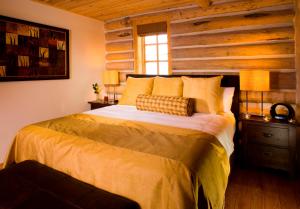 a bedroom with a bed and a wooden wall at Trappers Cabin in Beaver Creek