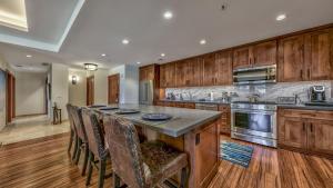 a kitchen with wooden cabinets and a large island with bar chairs at Luxury 3Br Residence Steps From Heavenly Village & Gondola Condo in South Lake Tahoe