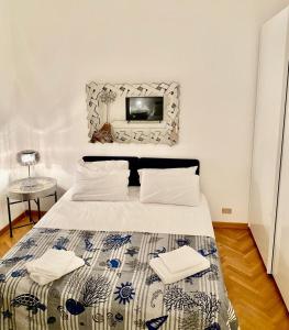 a bedroom with a bed with a tv on the wall at Corso Italia 4 in Bordighera