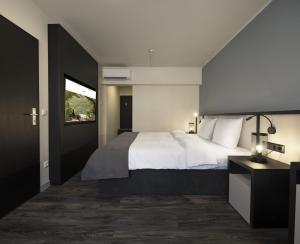 una camera da letto con un grande letto bianco e una finestra di Hotel Innsento - Health Campus Passau a Passavia