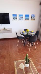 ポルティマンにあるMa vue mer en Algarveのリビングルーム(テーブル、椅子、テレビ付)