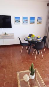 ein Wohnzimmer mit Tisch und Stühlen und einem Fernseher in der Unterkunft Ma vue mer en Algarve in Portimão