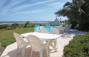 a white table and chairs next to a pool at Amazing Home In Pleubian in Pleubian