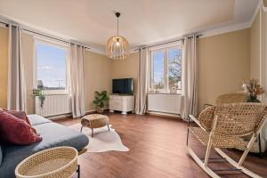 a living room with a couch and chairs and a tv at Wohnen bei der alten Dampflok inkl Balkon - 5 min zum Ravensburger Spieleland in Meckenbeuren