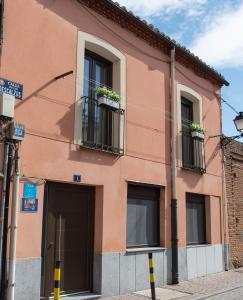 różowy budynek z oknami wychodzącymi na ulicę w obiekcie Casa Abuela Carmen w mieście Arévalo