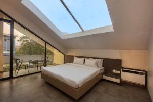 a bedroom with a bed and a skylight at SaffronStays Stargazer, Karjat - luxury pool villa with lake view in Karjat