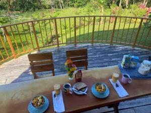 a wooden table with plates of food on a balcony at Chorotega Cabina in Monteverde Costa Rica
