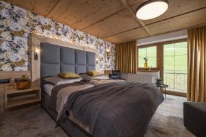 Schlafzimmer mit einem großen Bett mit blauem Kopfteil in der Unterkunft Hotel Burgschrofn in Tux