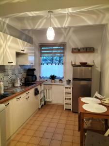 a kitchen with white cabinets and a table and a window at Stacja Kocham Morze in Gdańsk