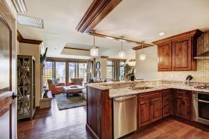 a kitchen with wooden cabinets and a living room at Ritz 2Br R208 in Vail