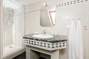 een badkamer met een wastafel, een douche en een spiegel bij Ferienwohnung Fortuna II in Thiessow