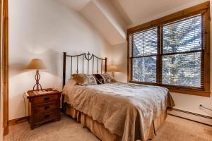 a bedroom with a large bed and a window at Ski Tip Townhomes 8713 in Keystone