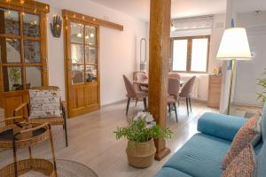 a living room with a blue couch and a table at Casa Abuela Carmen in Arévalo