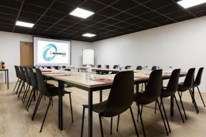 a conference room with a long table and chairs at The Originals City, Tabl'Hôtel, Amiens in Longueau