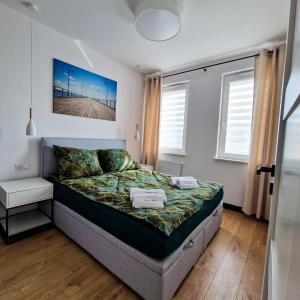 a small bedroom with a bed and a window at Piękny Puck Apartamenty z tarasami in Puck