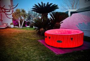 una bañera de hidromasaje roja sentada en el césped en un patio en Loft Terracina en Terracina